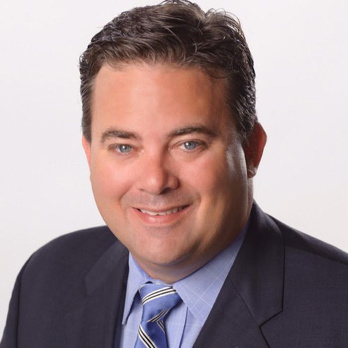 A man in a suit and tie smiles for the camera