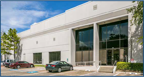 A large white building with cars parked in front of it.