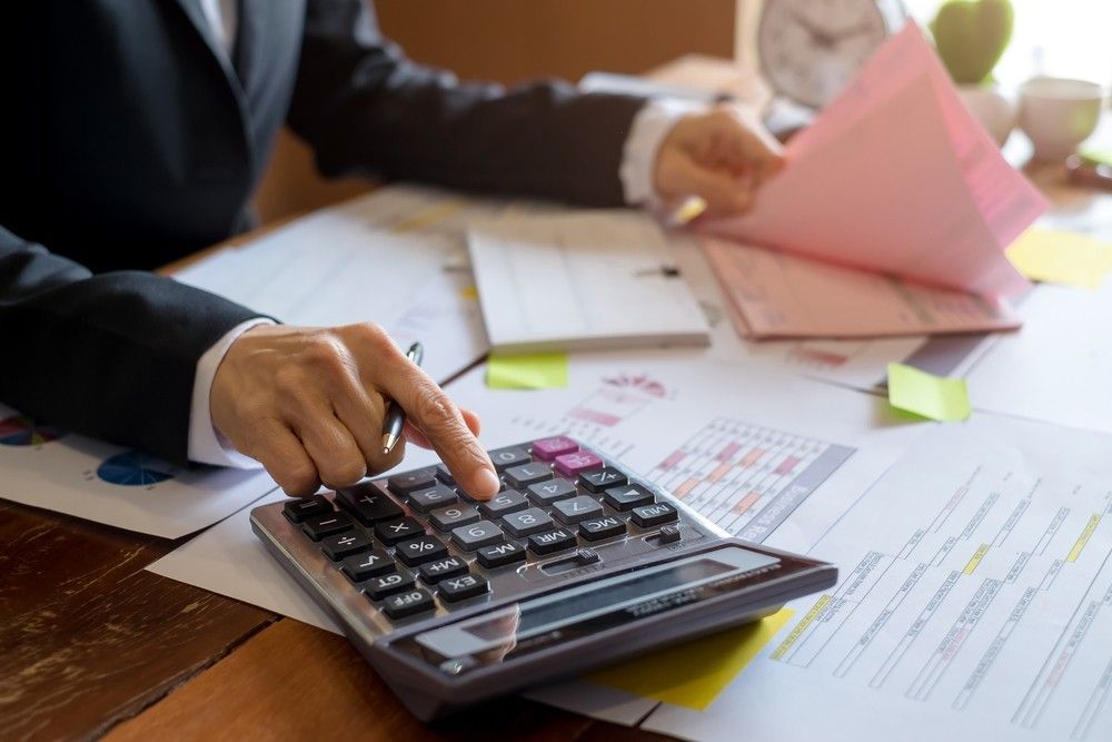 A Person is Using a Calculator at a Desk — Rauseo Group in Zuccoli, NT
