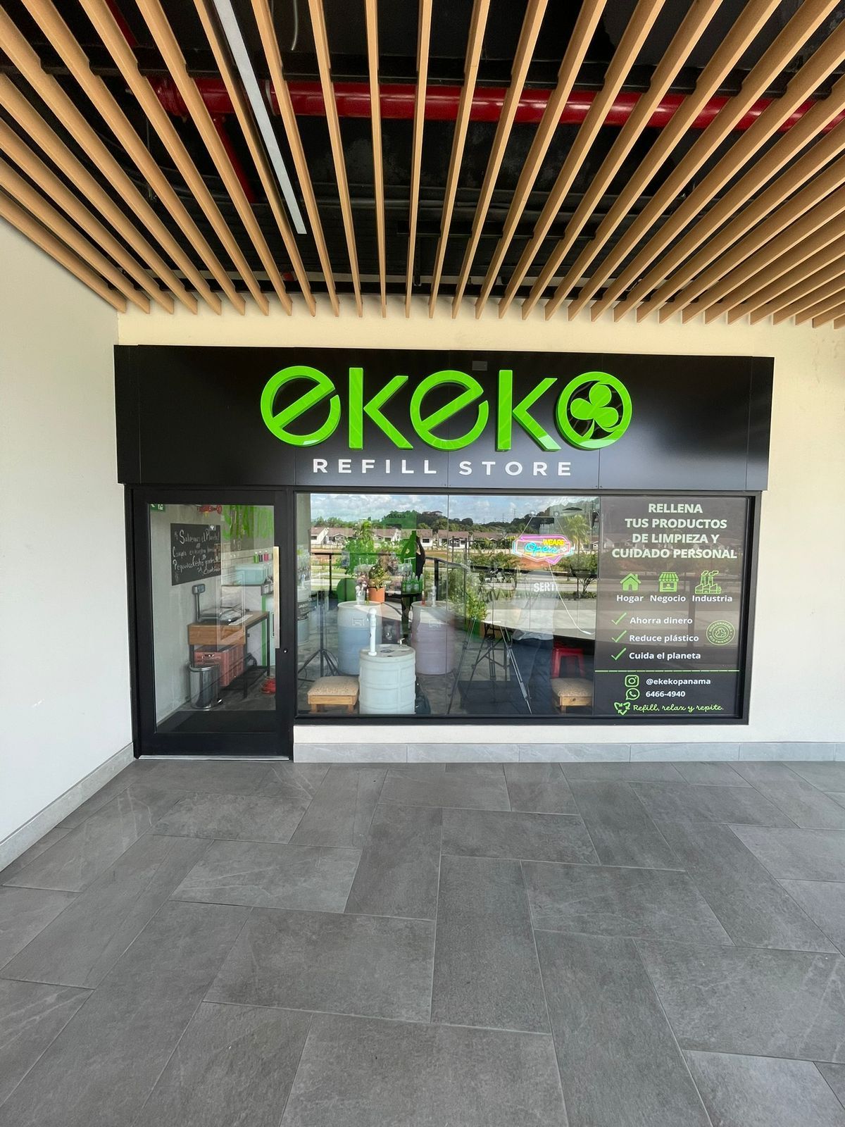 Fachada de la tienda Ekeko Refill Store en Panamá con letrero de neón verde.