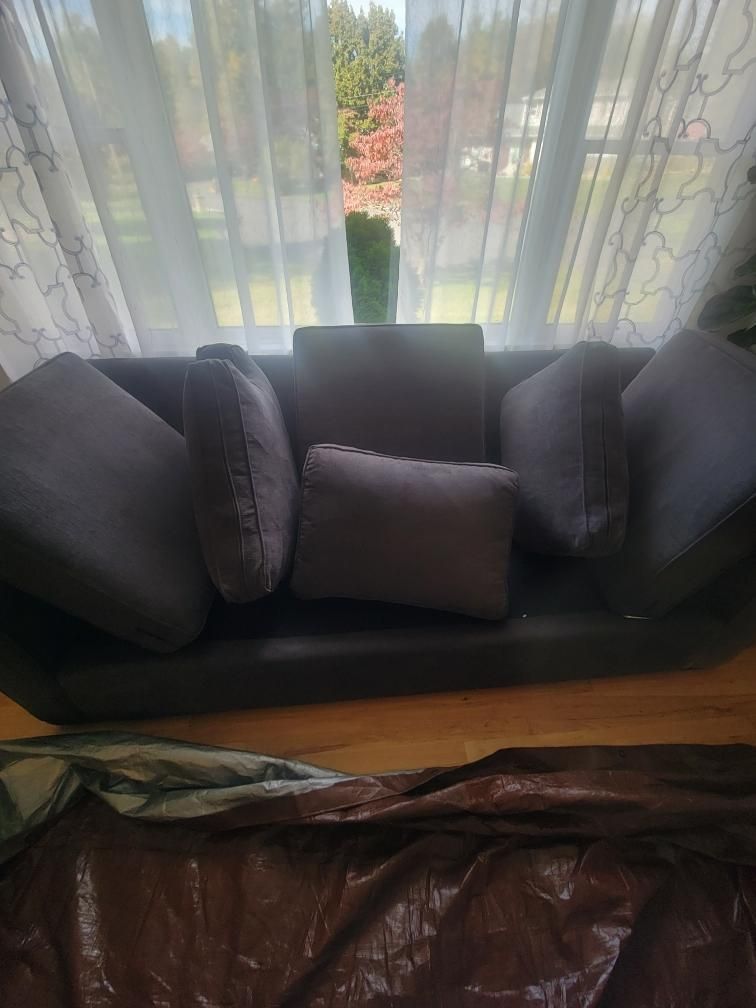 A couch is sitting in front of a window in a living room.