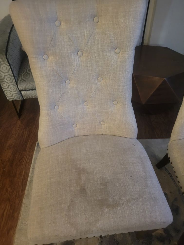 A white chair with buttons on the back is sitting in a living room.