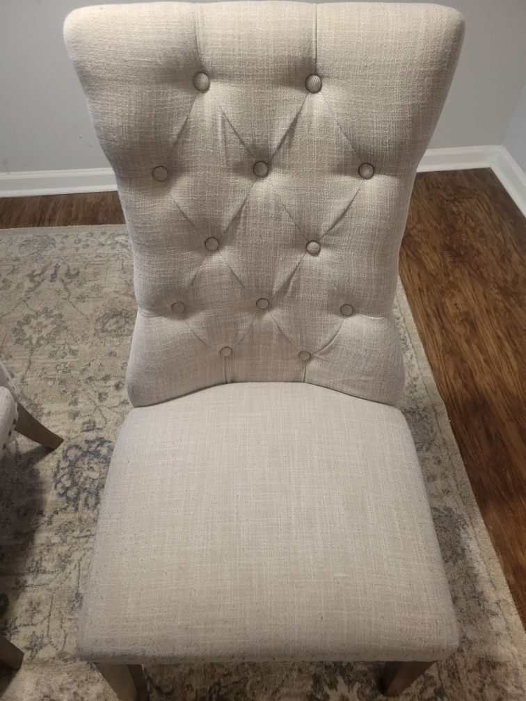 A white chair is sitting on a rug in a living room.