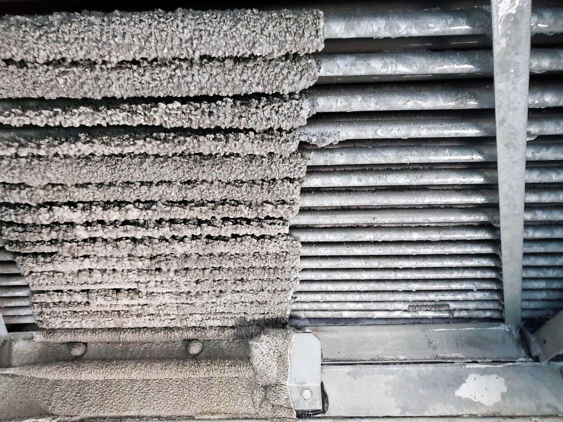 Stacked rough concrete blocks beside horizontal metal pipes in an industrial setting