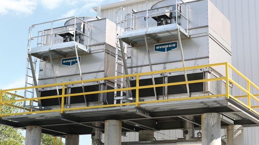 Industrial facility with silver tanks and yellow-railed platform outdoors