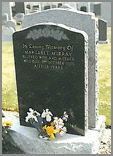 a deeplyBlack granite memorial with single rose head and leaves deep carved. 