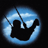 A silhouette of a child riding a swing in the night sky.