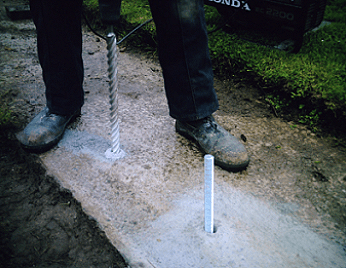 A person is using a drill to drill a hole in a concrete wall.