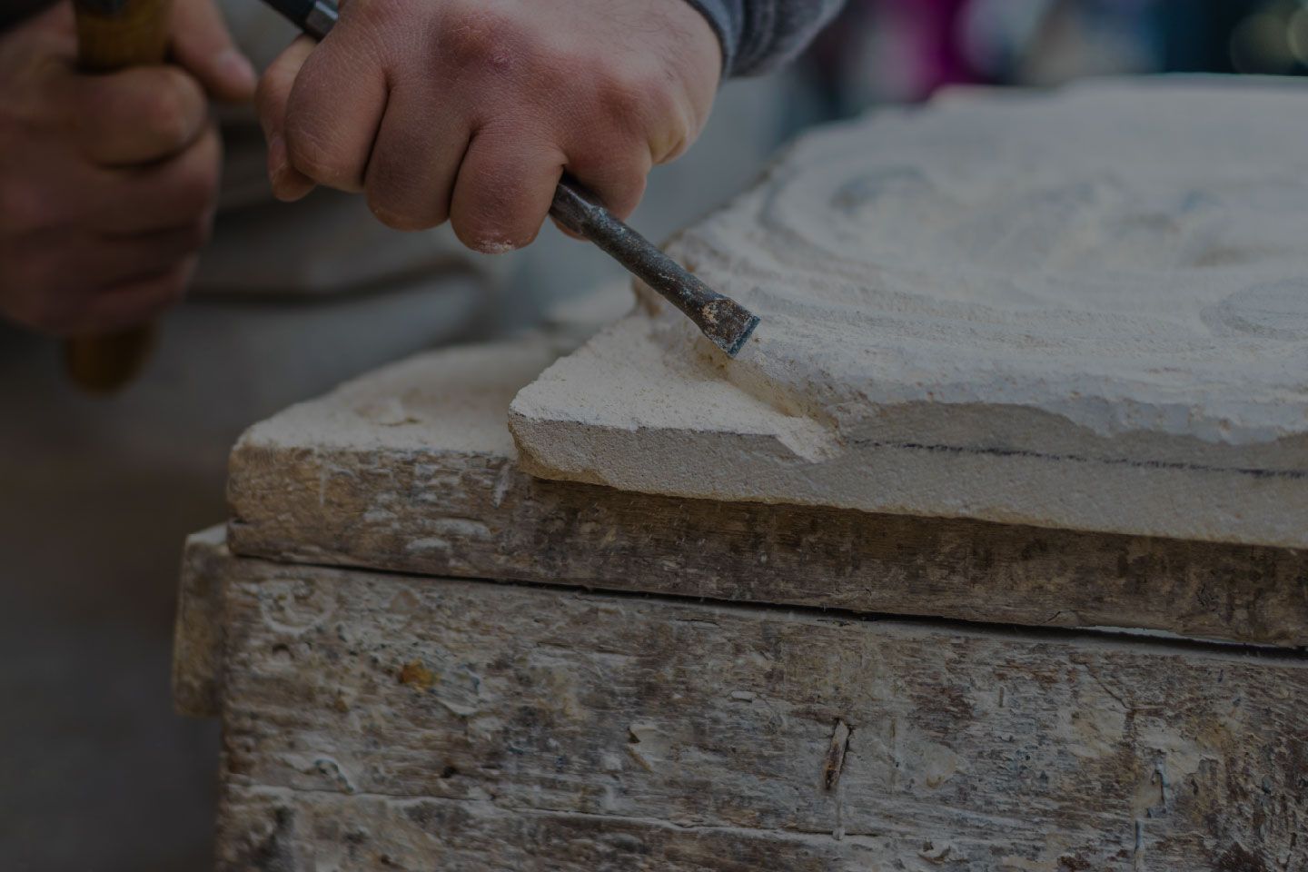 A person is carving a piece of stone with a chisel.