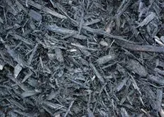 Close-up of dark gray mulch with rough wood chips and bark pieces