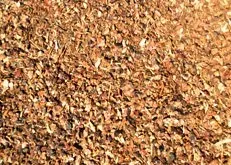 Close-up of a brown, textured pile of dried leaves or bark mulch