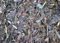 Close-up of dark brown wood mulch with scattered gray and tan pieces