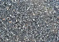 Close-up of gray gravel stones with scattered white and tan specks