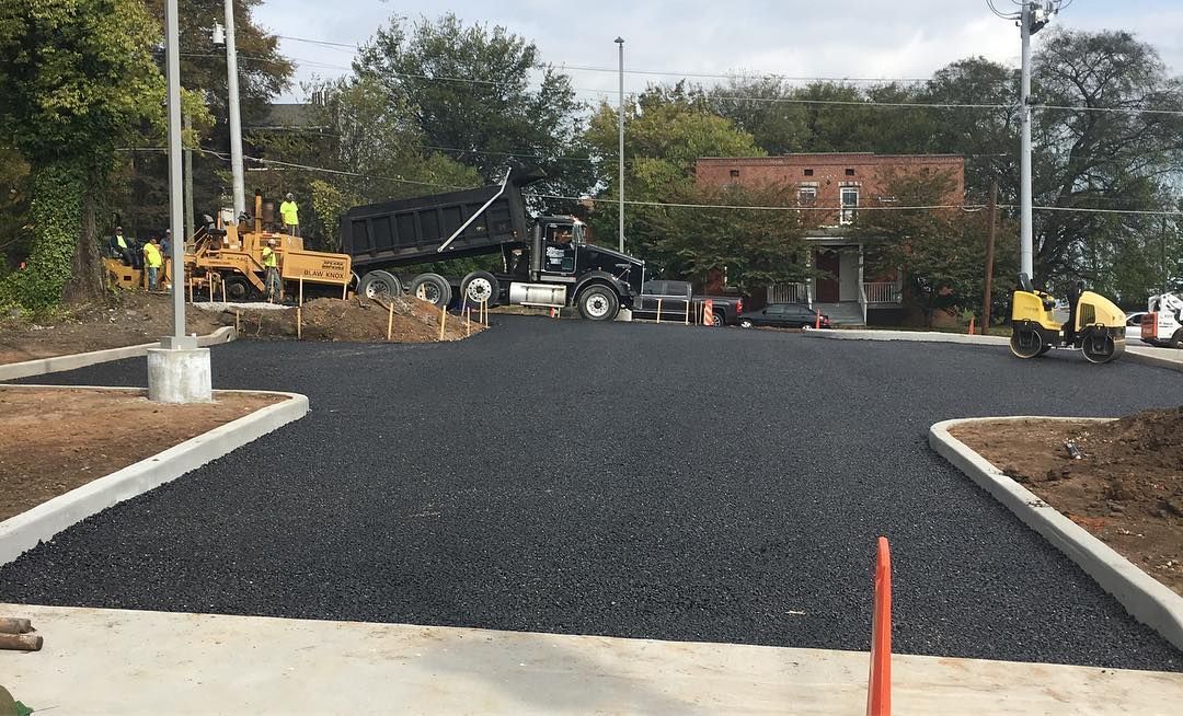 A truck is dumping gravel into a parking lot.