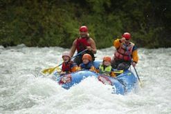 A group of people are rafting down a river in a raft.