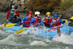 A group of people are rafting down a river on a raft.
