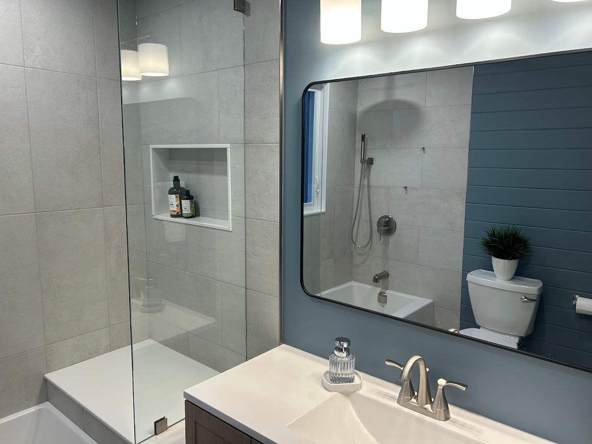 Modern bathroom with shower, toilet, and vanity. Blue and white color scheme.