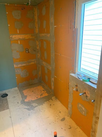 Orange tile backerboard installed in a bathroom shower area, ready for tiling.