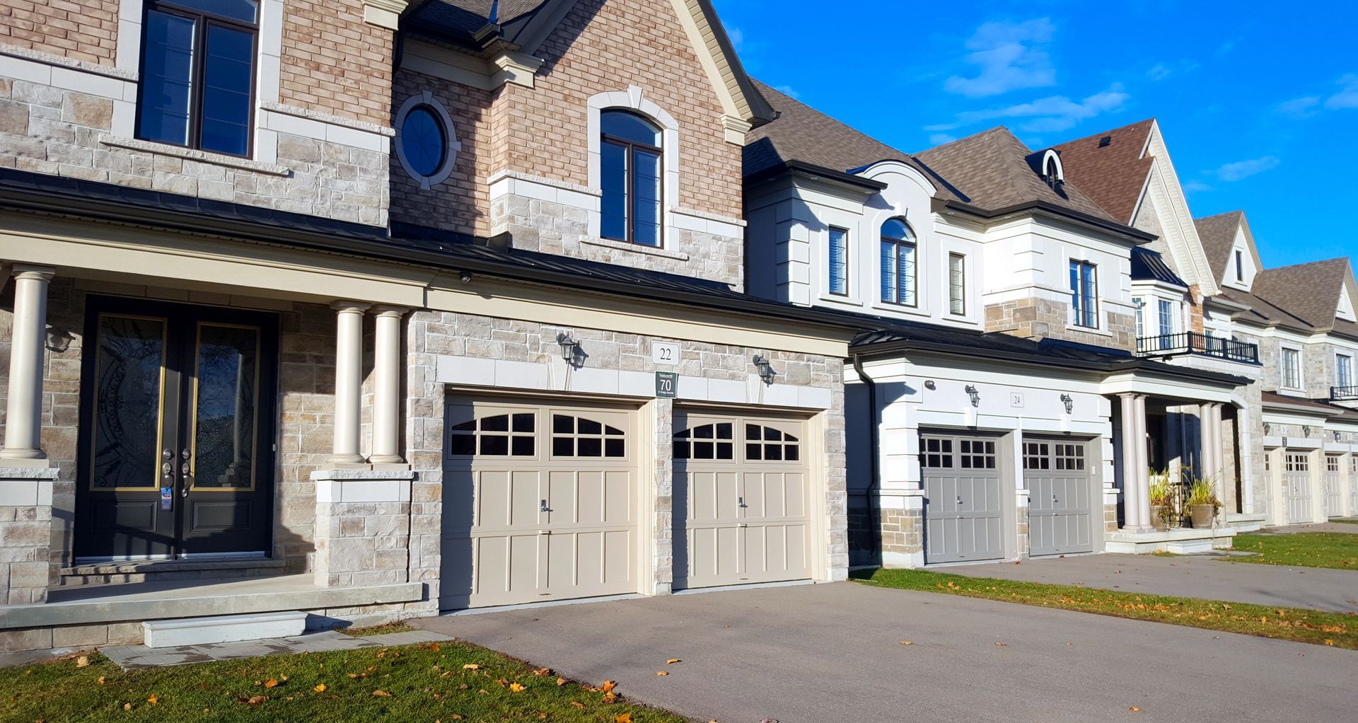 A row of houses with garage doors in a residential area.