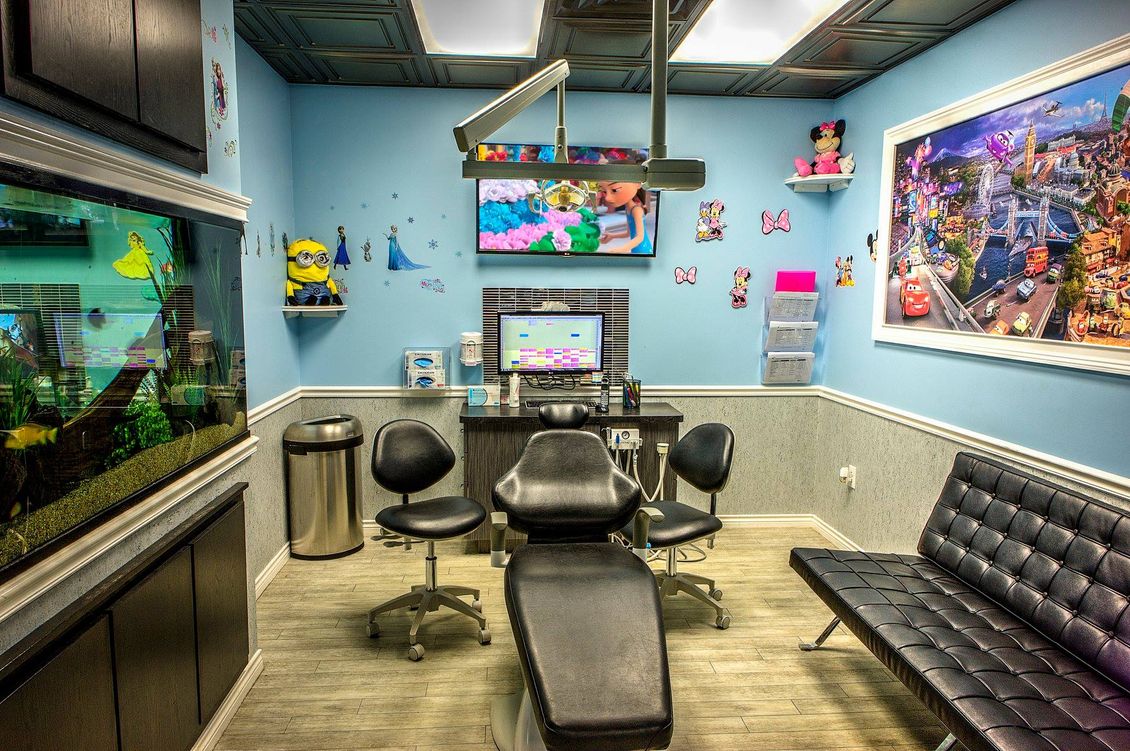 Fish-themed waiting room with blue walls, black seating, and an aquarium on the left.