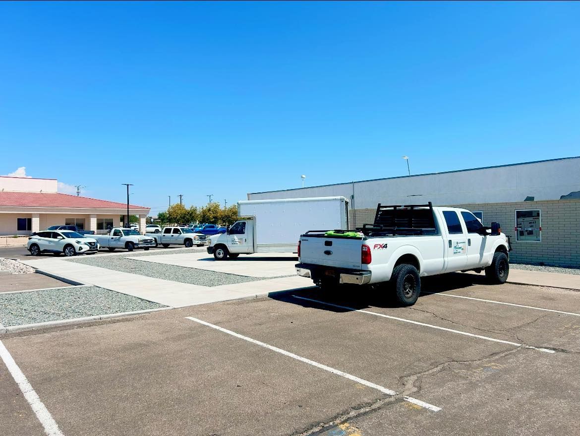 White truck parked in a lot with other vehicles. Clear blue sky.
