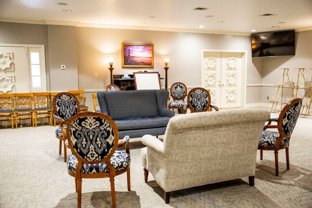 A living room with a couch , chairs , and a television.