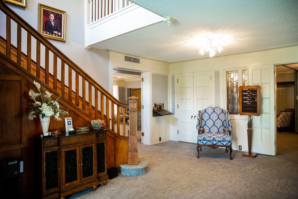 A living room with stairs , a couch , and a picture on the wall.
