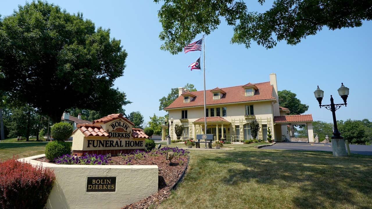 A funeral home with a sign in front of it