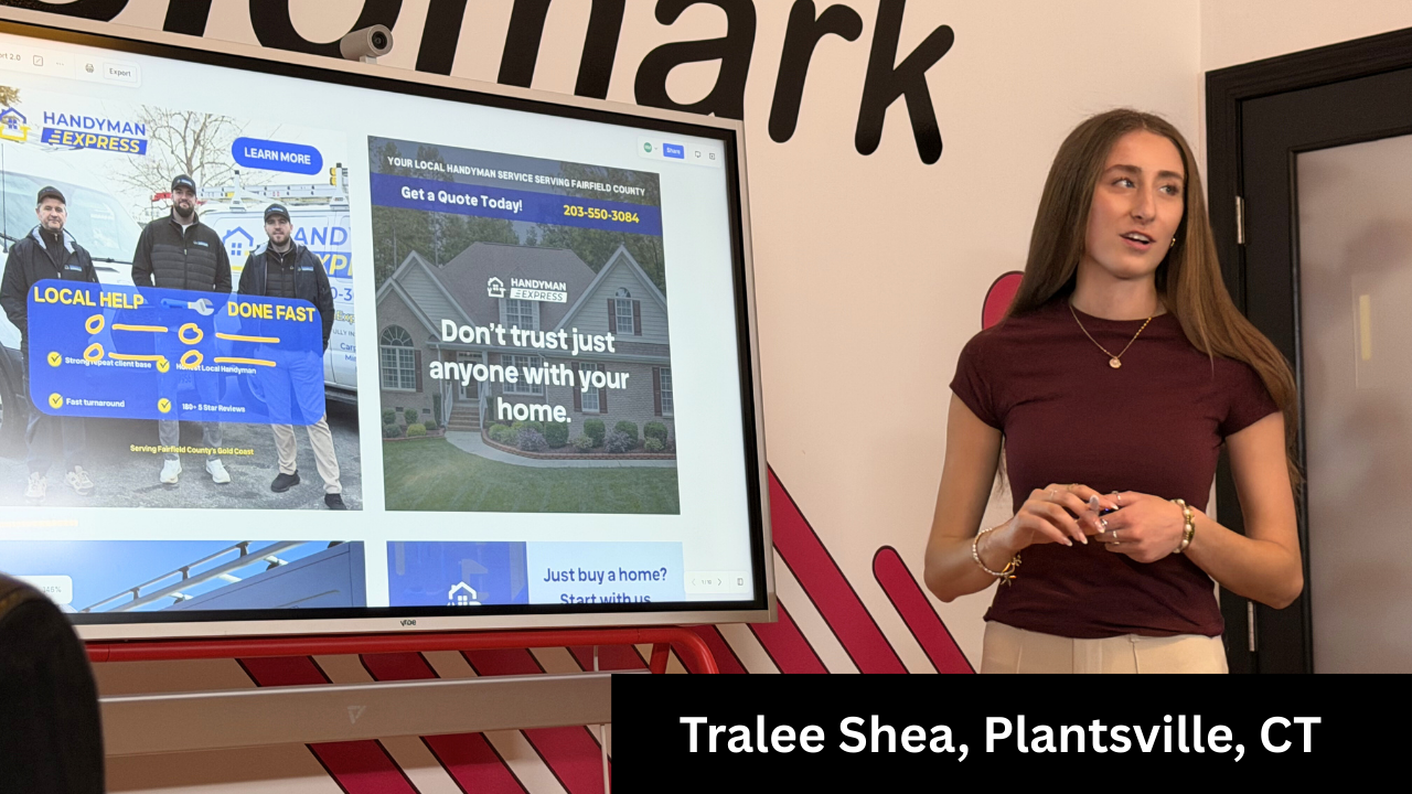 Woman presenting in front of a screen displaying a website. A banner at the bottom reads 