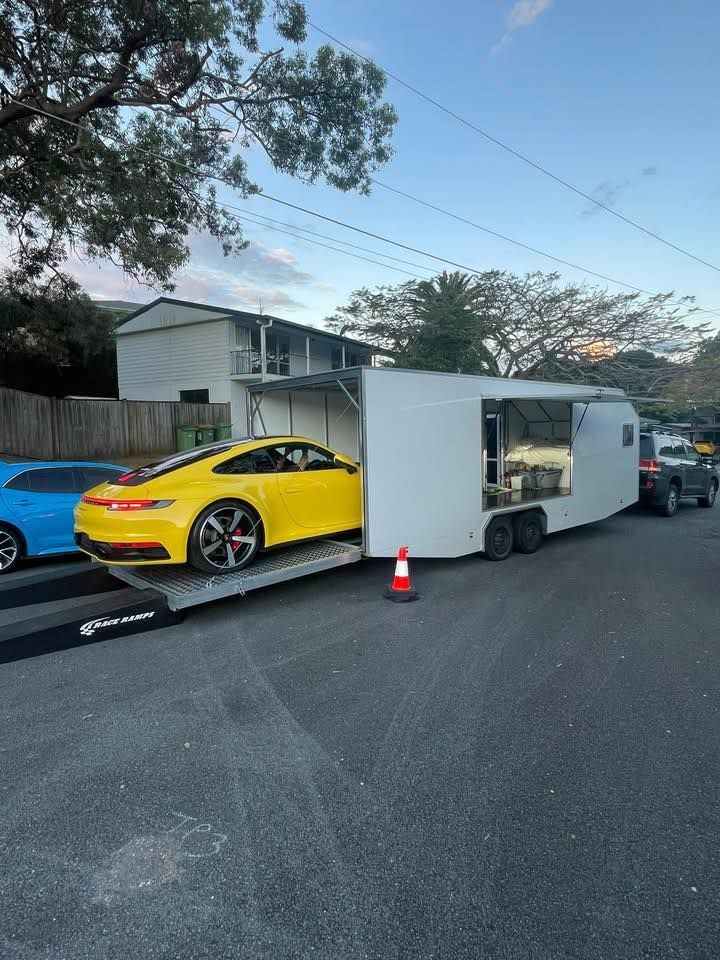 Yellow Porsche being loaded onto a white trailer — Full Throttle Enclosed Car Transport in Kilmore, VIC