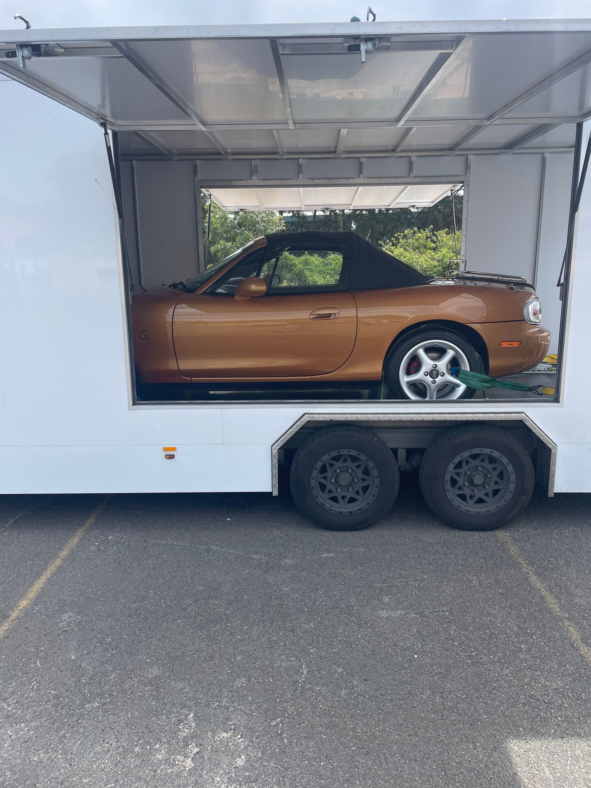 Orange sports car inside an open white trailer on a road - Full Throttle Enclosed Car Transport in Kilmore, VIC