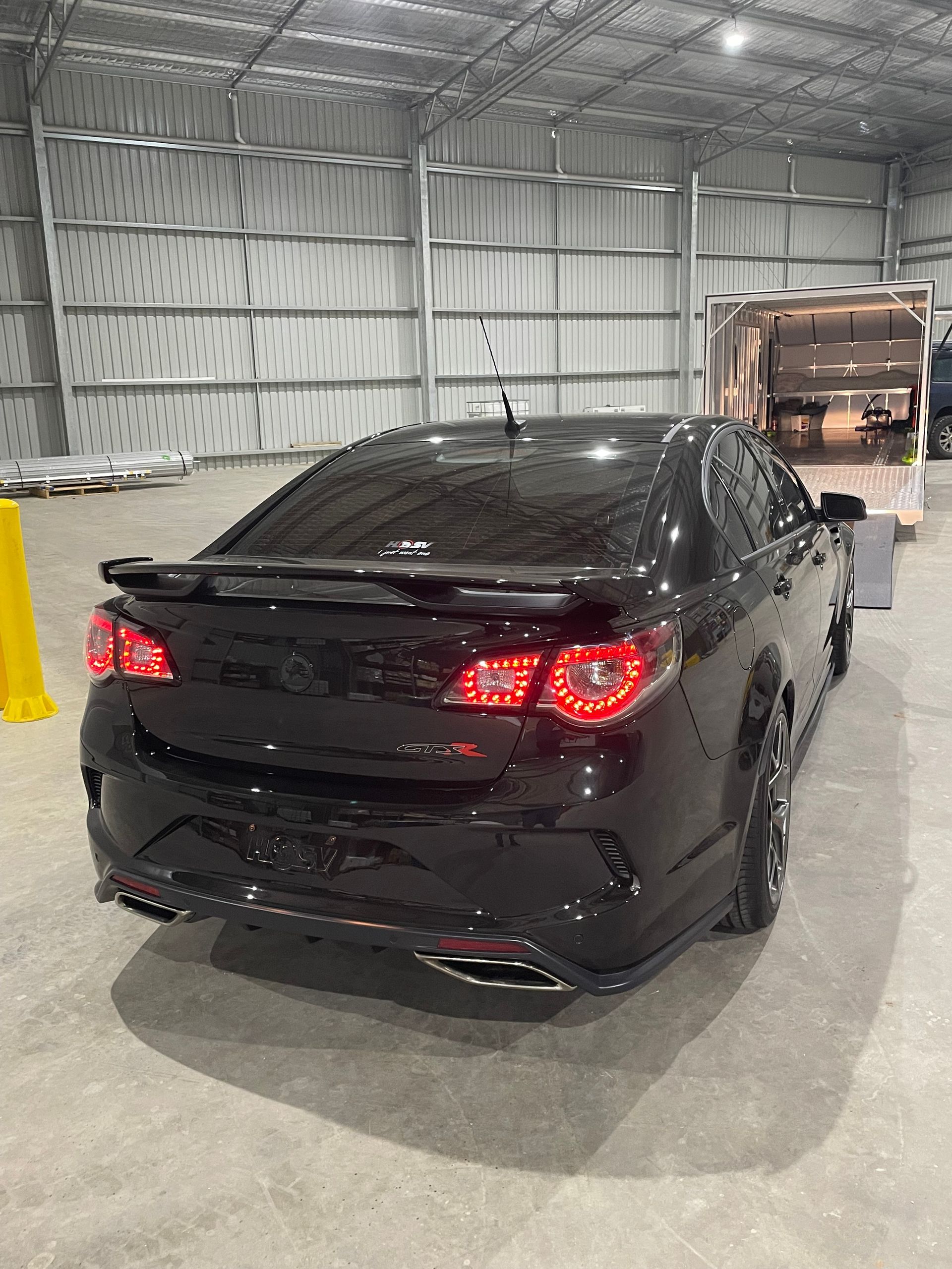 Black sedan in a warehouse — Full Throttle Enclosed Car Transport in Kilmore, VIC