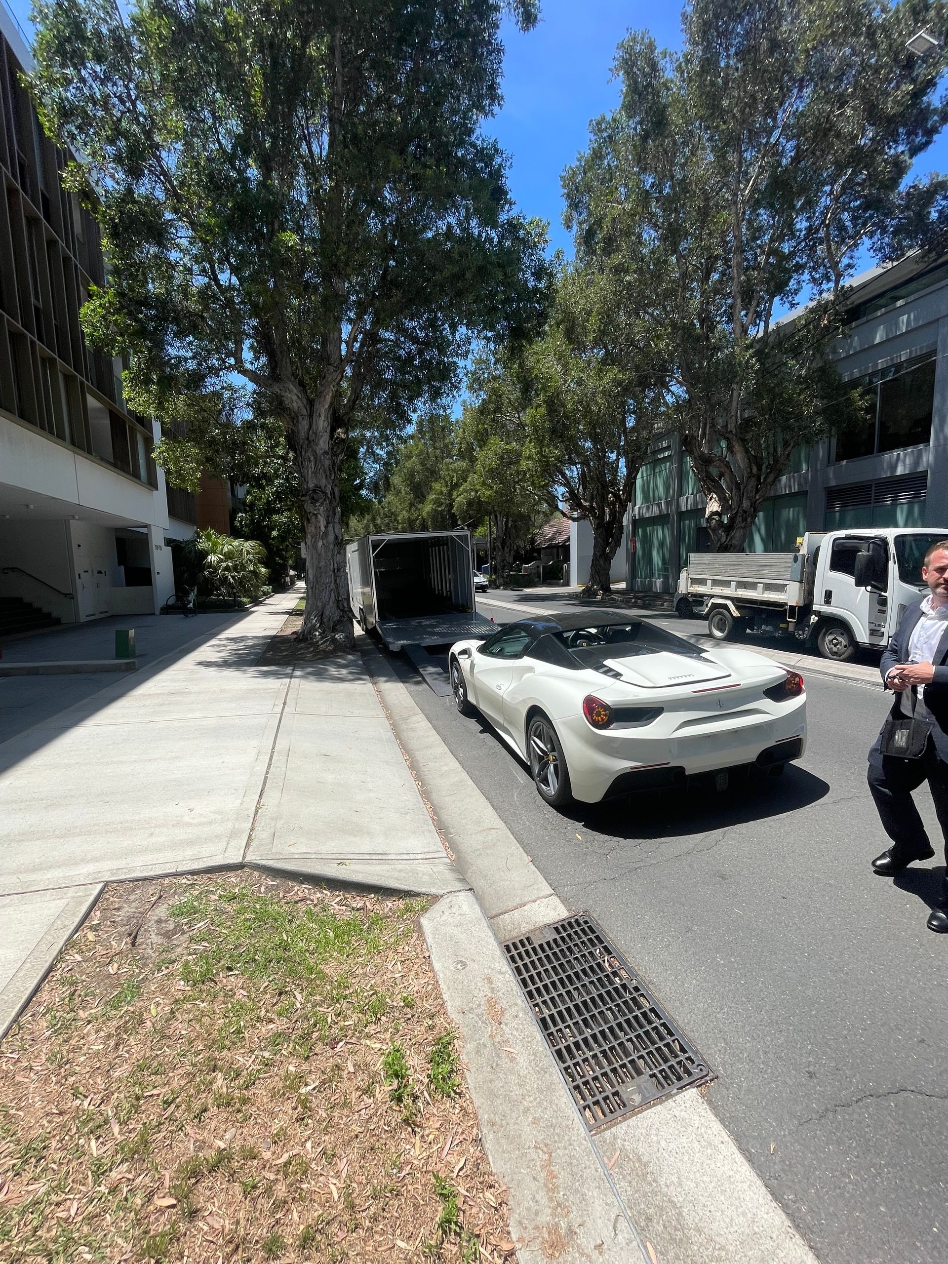 White convertible parked on a sunny street beside tall trees and buildings, Full Throttle Enclosed Car Transport in Kilmore, VIC
