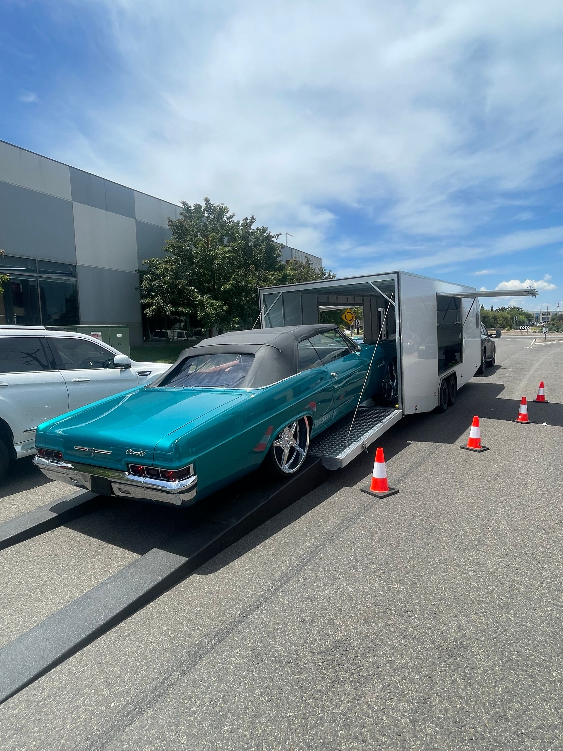 Turquoise classic car loaded on a trailer beside a building, Full Throttle Enclosed Car Transport in Kilmore, VIC