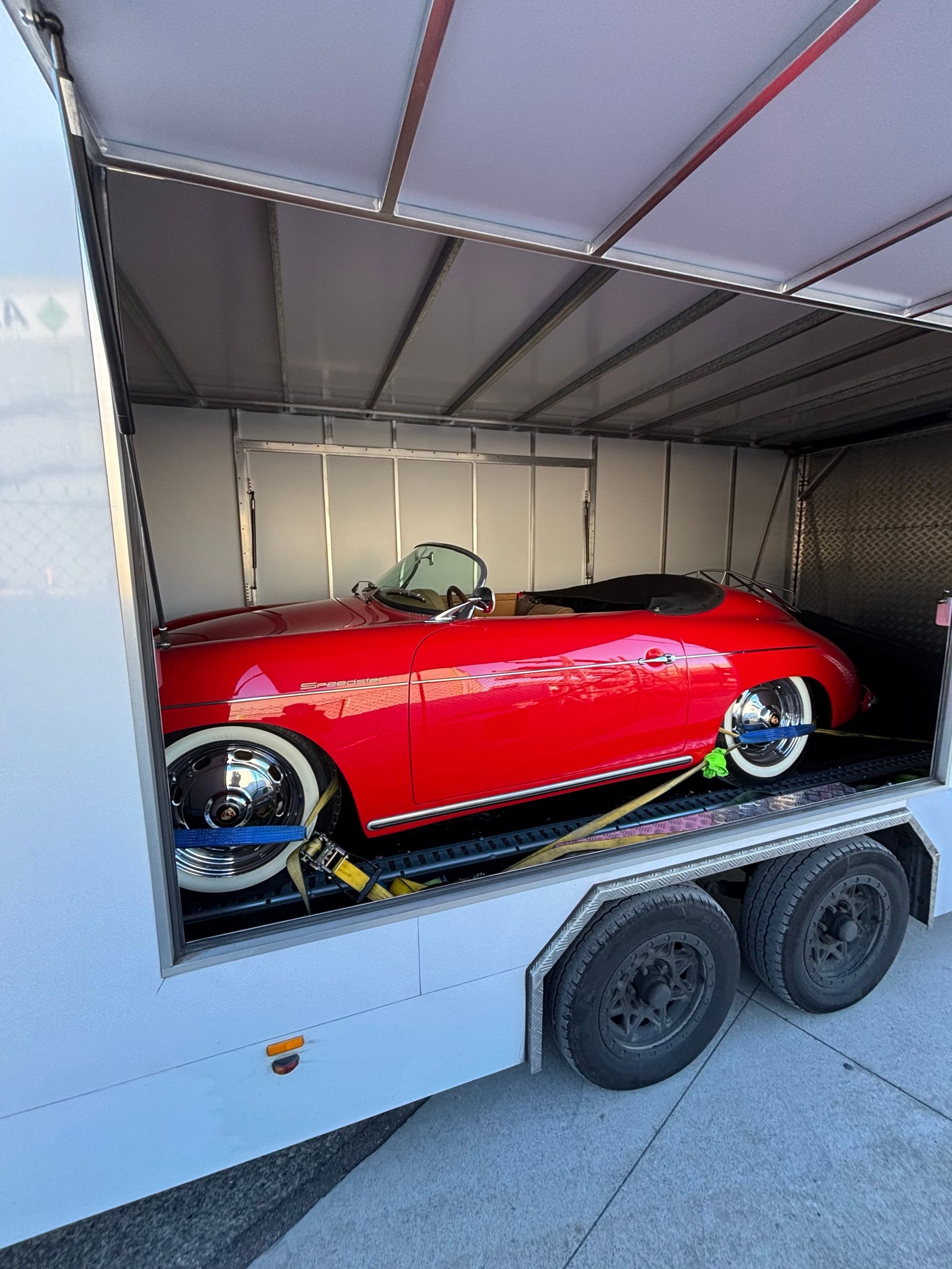 Red vintage convertible on a car trailer inside an enclosed transport trailer.- Full Throttle Enclosed Car Transport in Kilmore, VIC