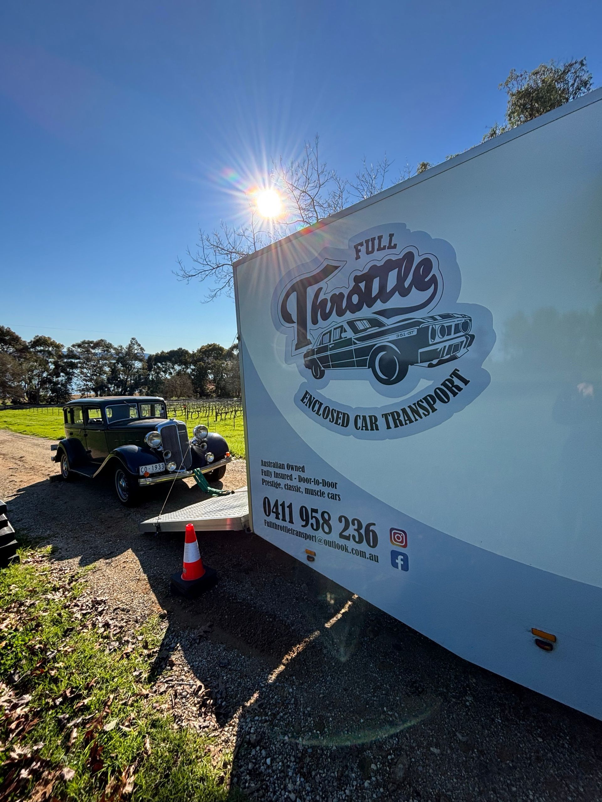 White food truck with logo parked outdoors beside a jeep and traffic cone in bright sunlight - Full Throttle Enclosed Car Transport in Kilmore, VIC