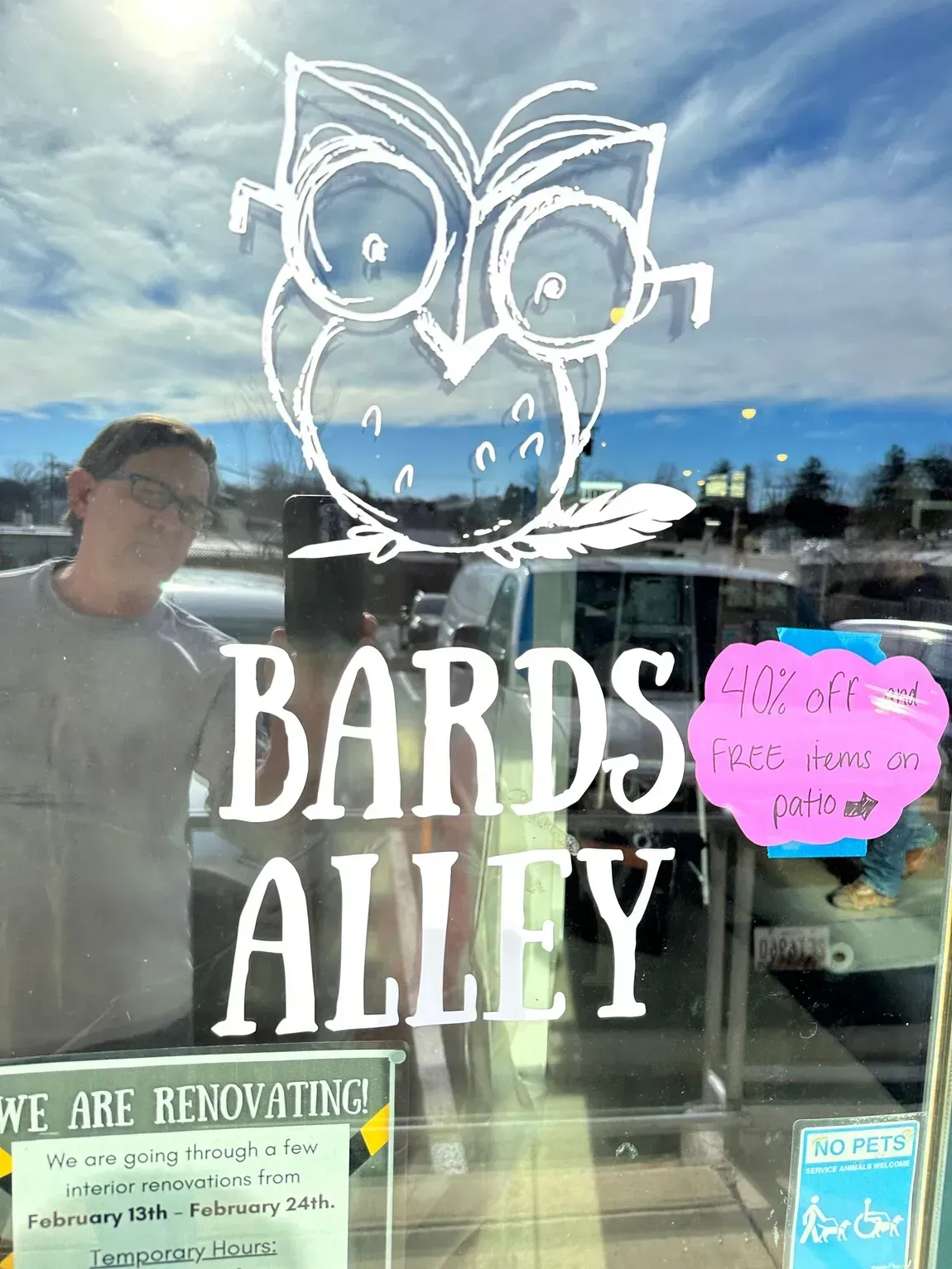 A man is standing in front of a sign that says bards alley.