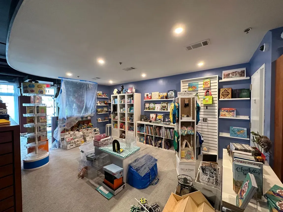A room filled with lots of toys and books on shelves.