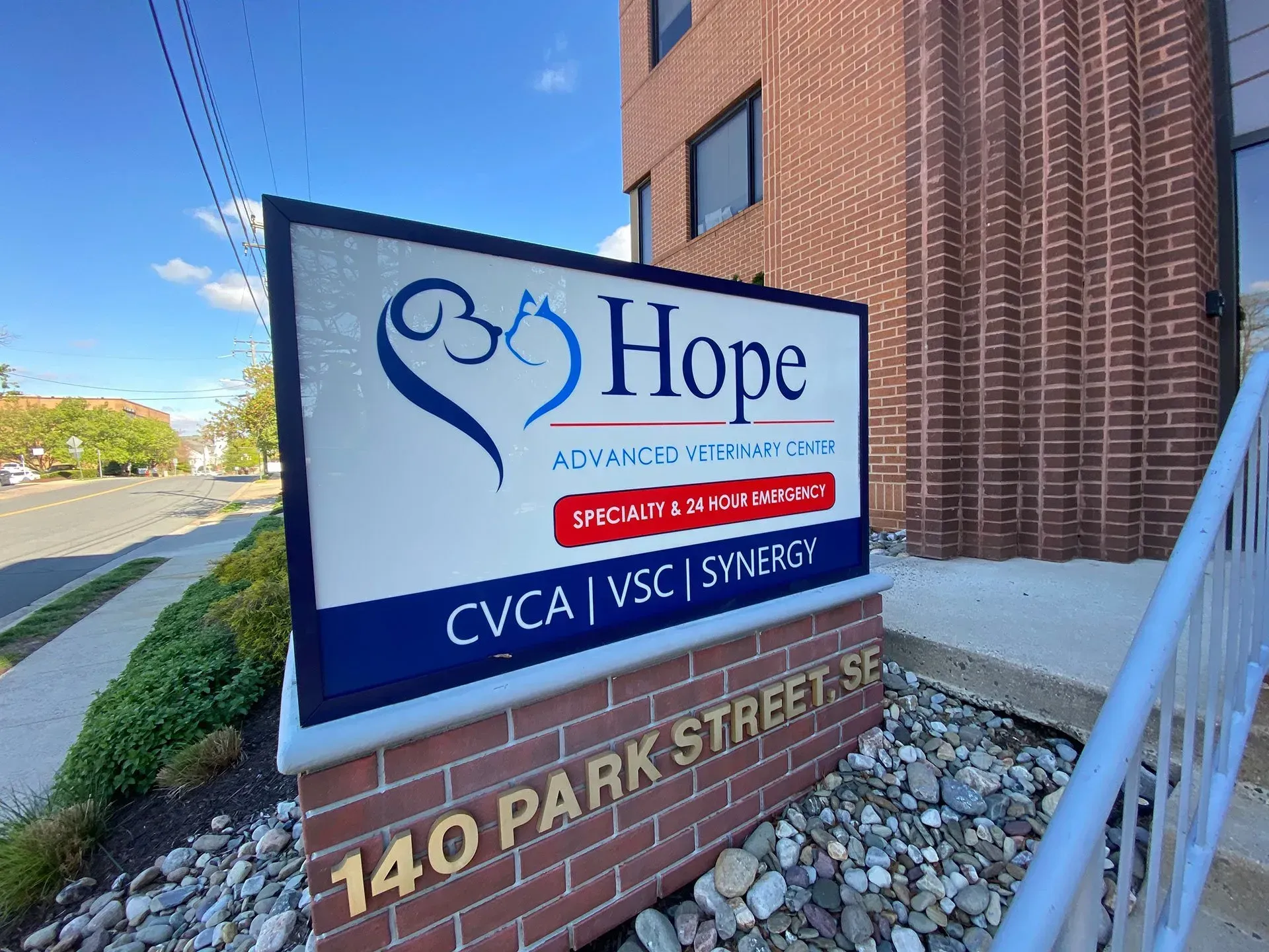 A hope sign is sitting in front of a brick building.