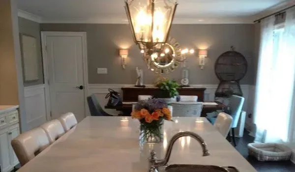 A kitchen with a sink and a table with a vase of flowers on it.