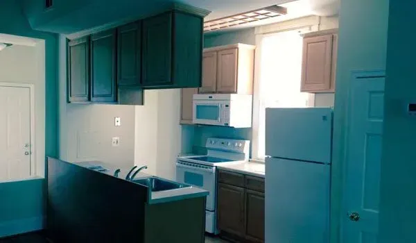 A kitchen with a refrigerator , stove , microwave and sink.