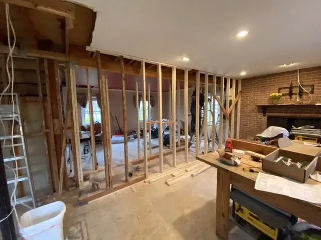 A living room is being remodeled with a brick fireplace.