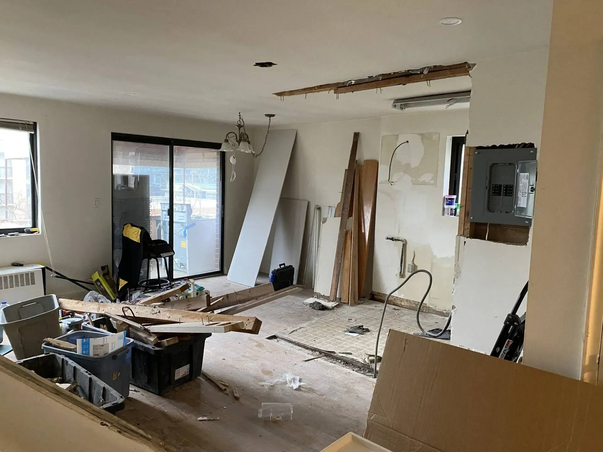 A living room under construction with a lot of boxes on the floor.