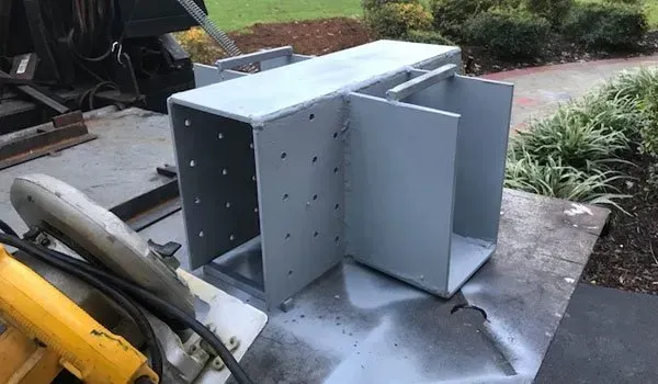 A piece of metal is sitting on top of a table next to a circular saw.