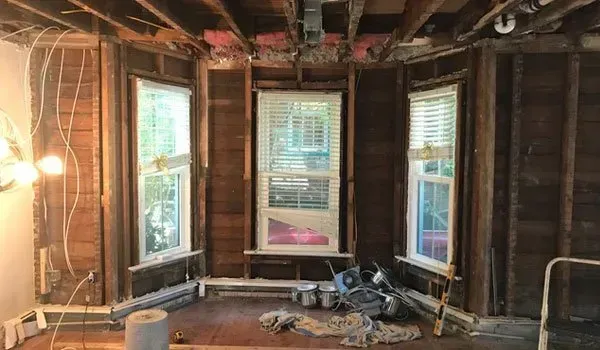 A room with a lot of windows and a ladder in it.