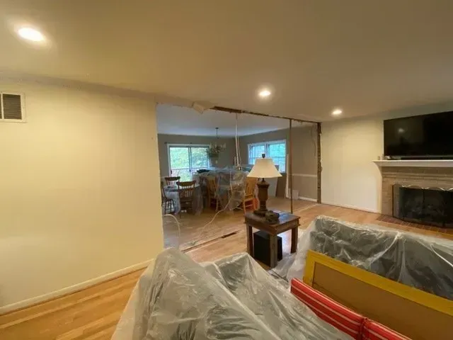 A living room with a couch, table, lamp and television.