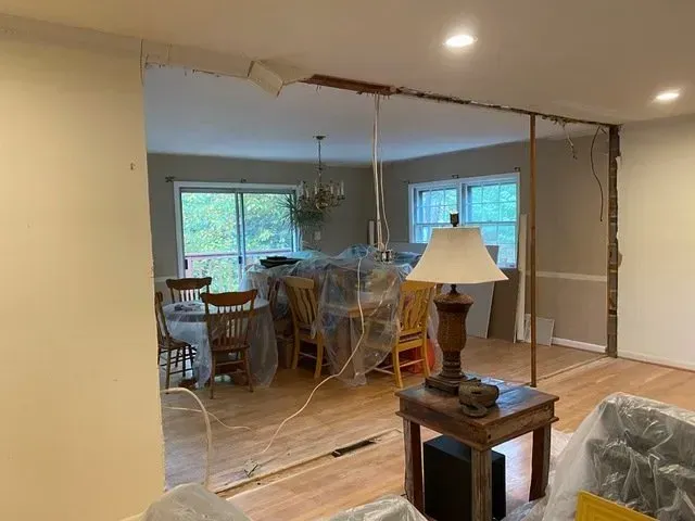 A living room with a table and chairs and a lamp.