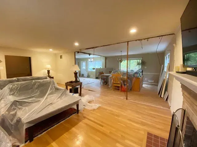 A living room with a couch covered in plastic and a fireplace.