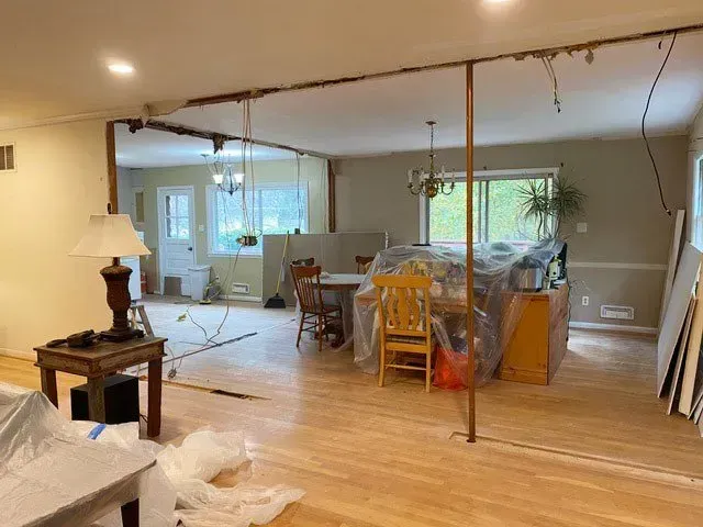 A living room with a table and chairs and a lamp.
