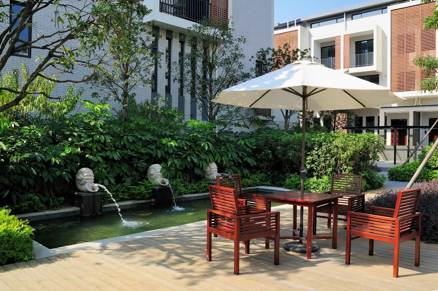 A table and chairs under an umbrella in a garden